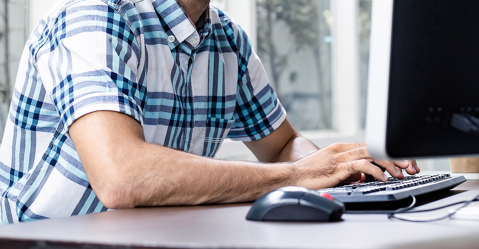 Young man working from home by computer.
